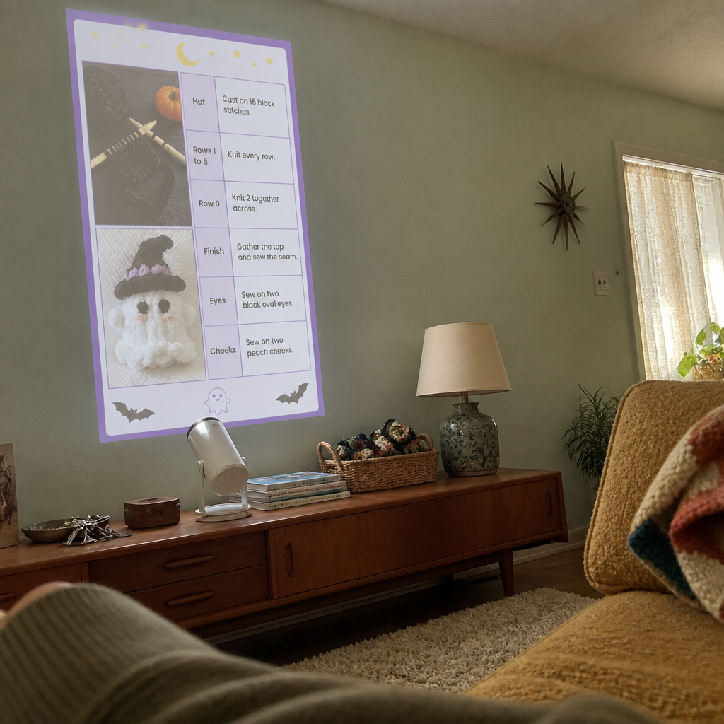 Projector on a teak sideboard in a mid-century living room showing a knitting pattern page on the wall
